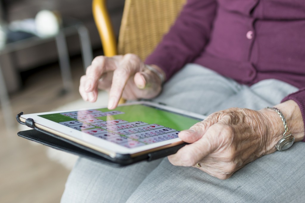 Woman Playing Solitaire on Tablet
